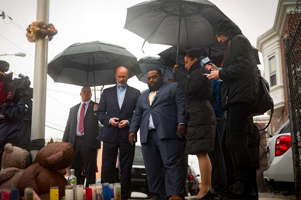 wolfe-phillyrep-memorial Elected officials standing in the rain looking a street memorial for a child killed by gunfire