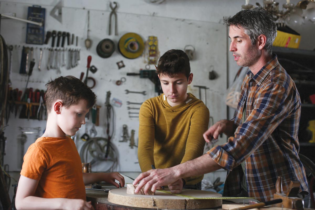 father and sons working in a shop